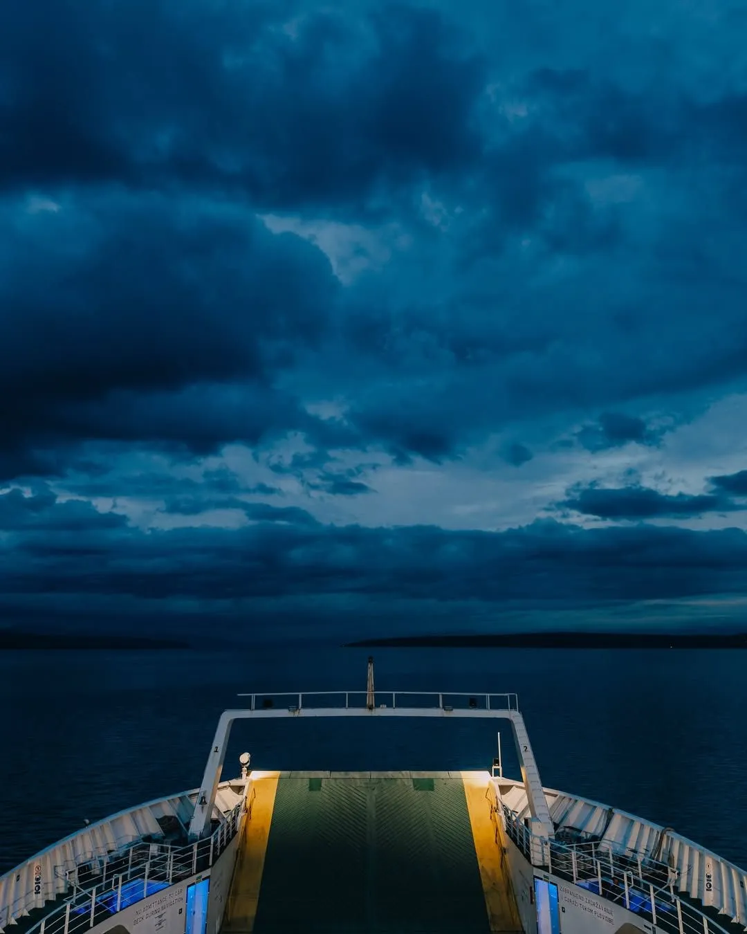 A large white Jadrolinija ferry navigating the blue waters of the Adriatic Sea near a Croatian island coast.