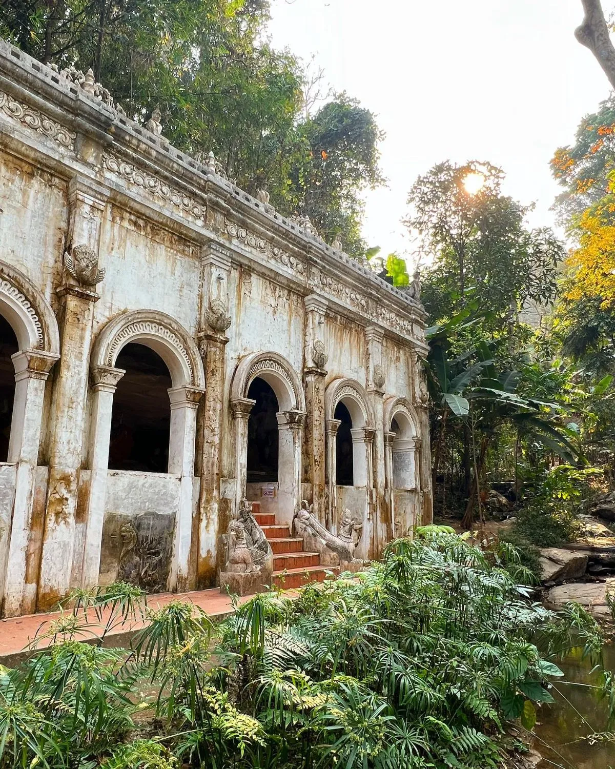 The ancient stone bridge and waterfall at Wat Pha Lat temple in the Chiang Mai jungle